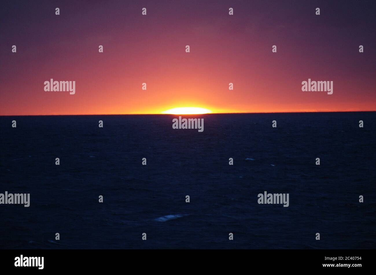 Bildfolge eines Sonnenuntergangs vom gleichen Aussichtspunkt, Sonnenuntergang im Meer, Skyline bei Dämmerung, Abenddämmerung Horizont über dem Meer Magenta Skyline Stockfoto