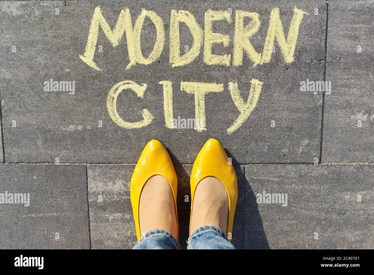 Modernes Stadtkonzept, Draufsicht auf Frauenbeine und Text in Kreide auf grauem Bürgersteig geschrieben Stockfoto
