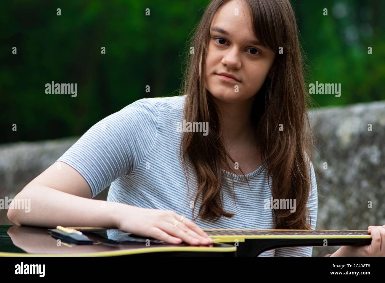 Portrait von Teenager Mädchen halten Gitarre im Freien Stockfoto