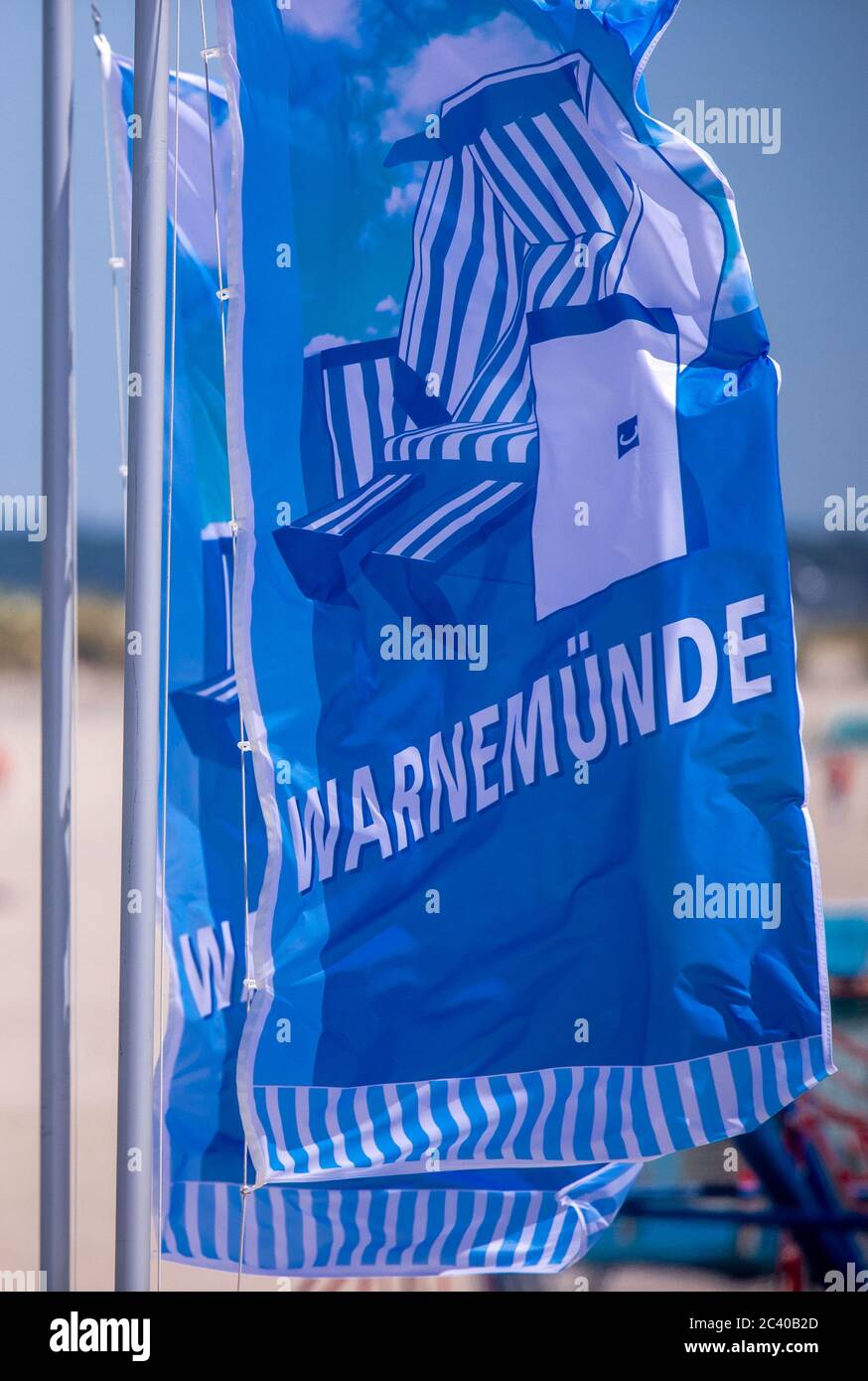15. Juni 2020, Mecklenburg-Vorpommern, Warnemünde: Am Ostseestrand von Warnemünde wehen Fahnen mit der Aufschrift Warnemünde. Foto: Jens Büttner/dpa-Zentralbild/ZB Stockfoto