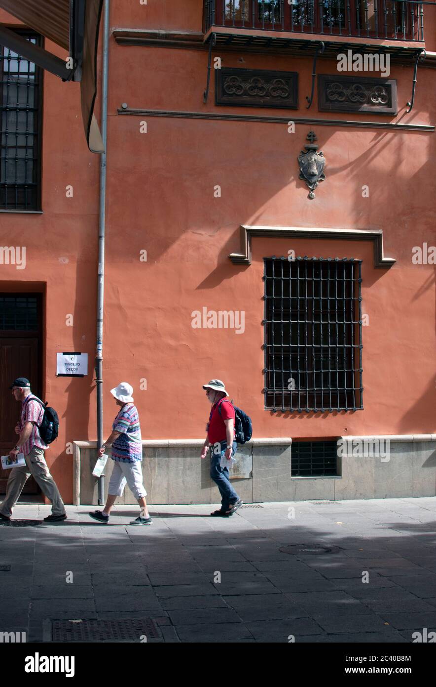 Die wunderschöne, historische spanische Stadt Granada. Touristen gehen an einem späten Sommertag an einem schönen alten Gebäude an der Plaza Bib Rambla in der Altstadt vorbei. Stockfoto