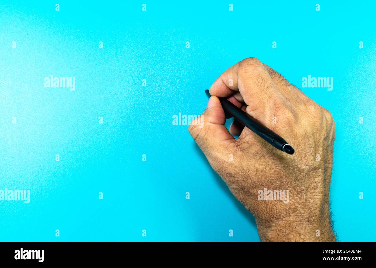 Eine Mann Hand schreiben auf einem blauen Hintergrund mit Platz für Text Stockfoto