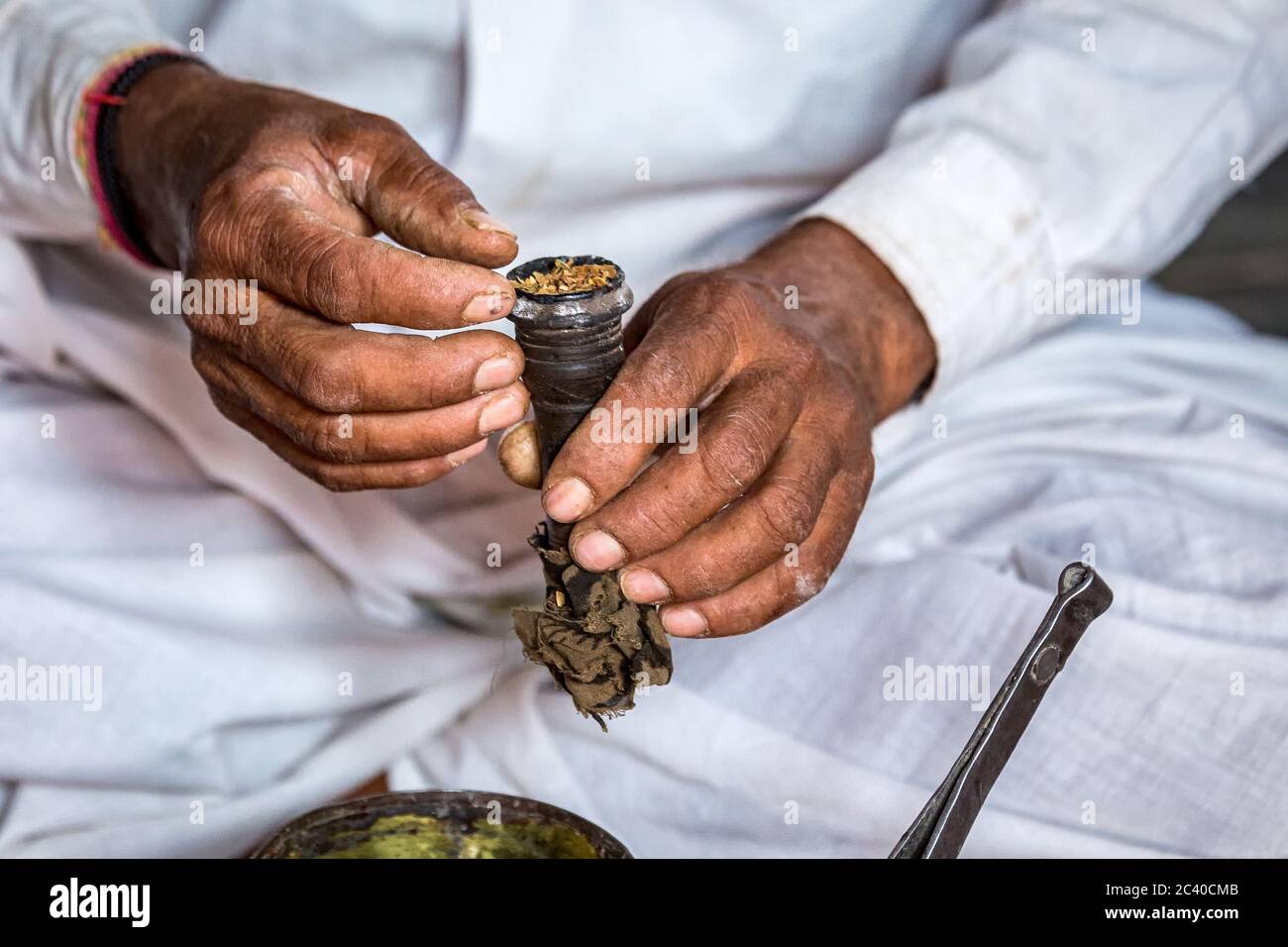 Hände von Raucher Preping Hand gemacht Pfeife Tabak zu rauchen, Indien. Stockfoto