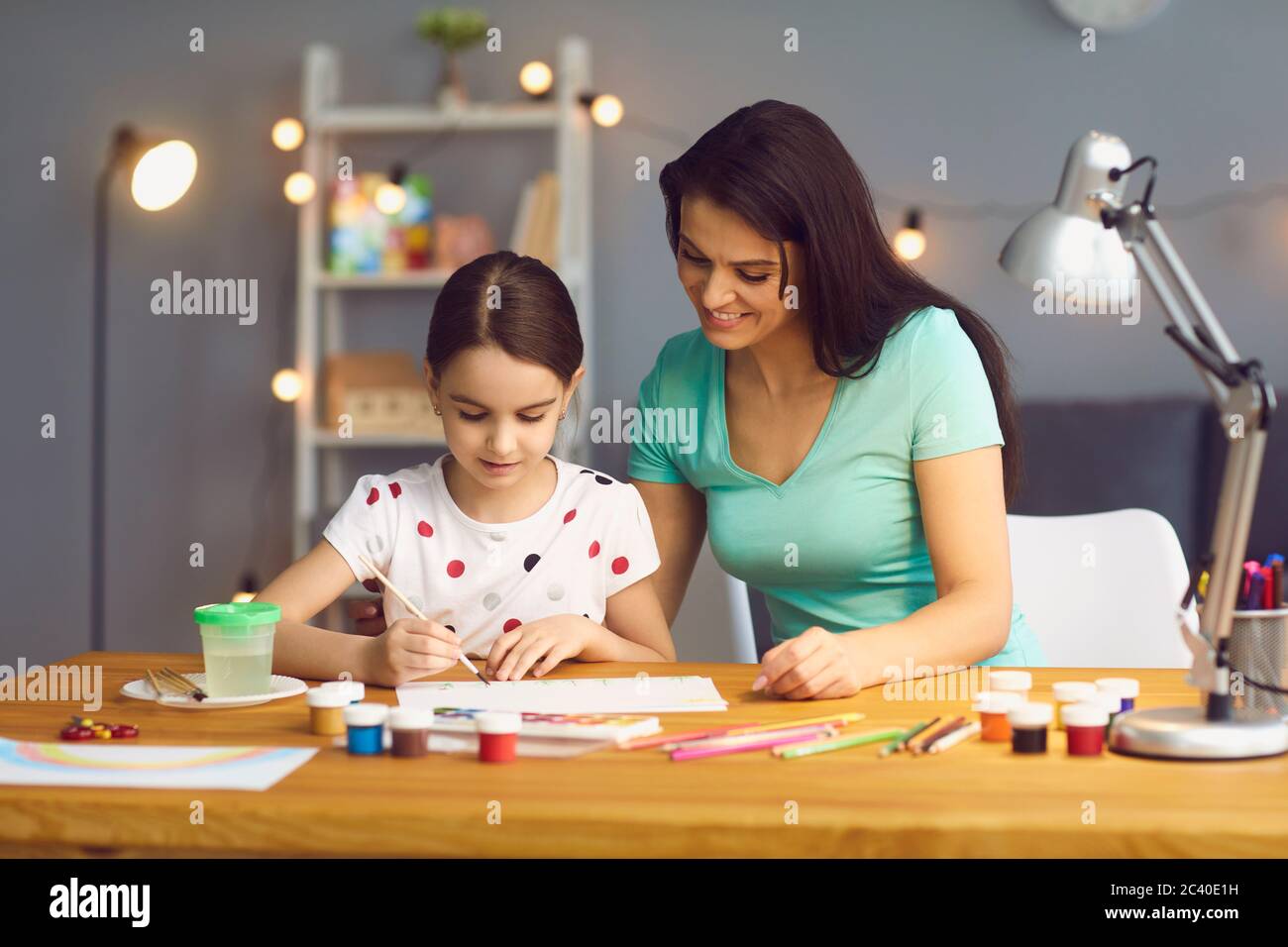 Kreativität und Entwicklung des Kindes. Glückliche Familie Mutter und Tochter zeichnen Farben am Tisch zu Hause. Stockfoto