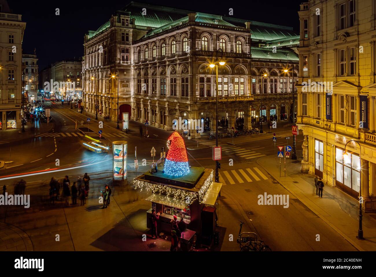 Blick auf die Wiener Staatsoper und die Menschen am Albertinaplatz bei Nacht. Die Lichter der Nacht Wien. Stockfoto