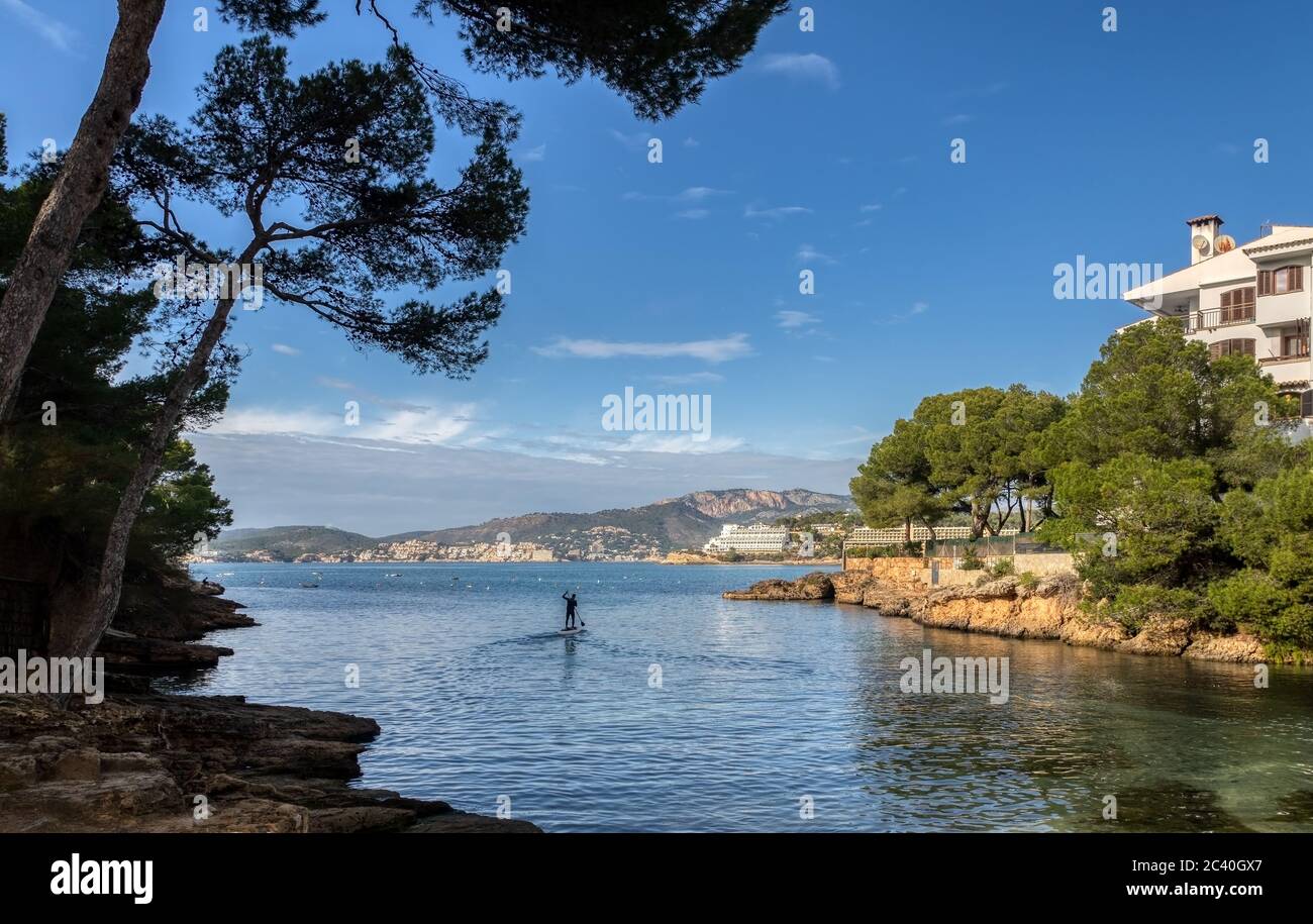 Eine Bucht im Urlaubsort Santa Ponca auf Mallorca mit Mann beim Standup Paddling Stockfoto