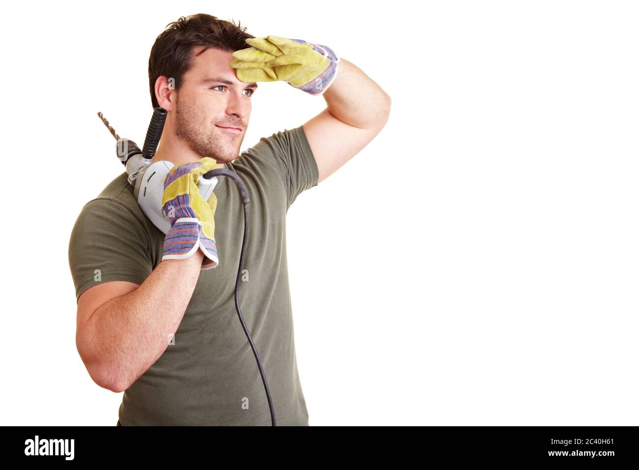 Handwerker mit Bohrer schaut in die Ferne Stockfoto