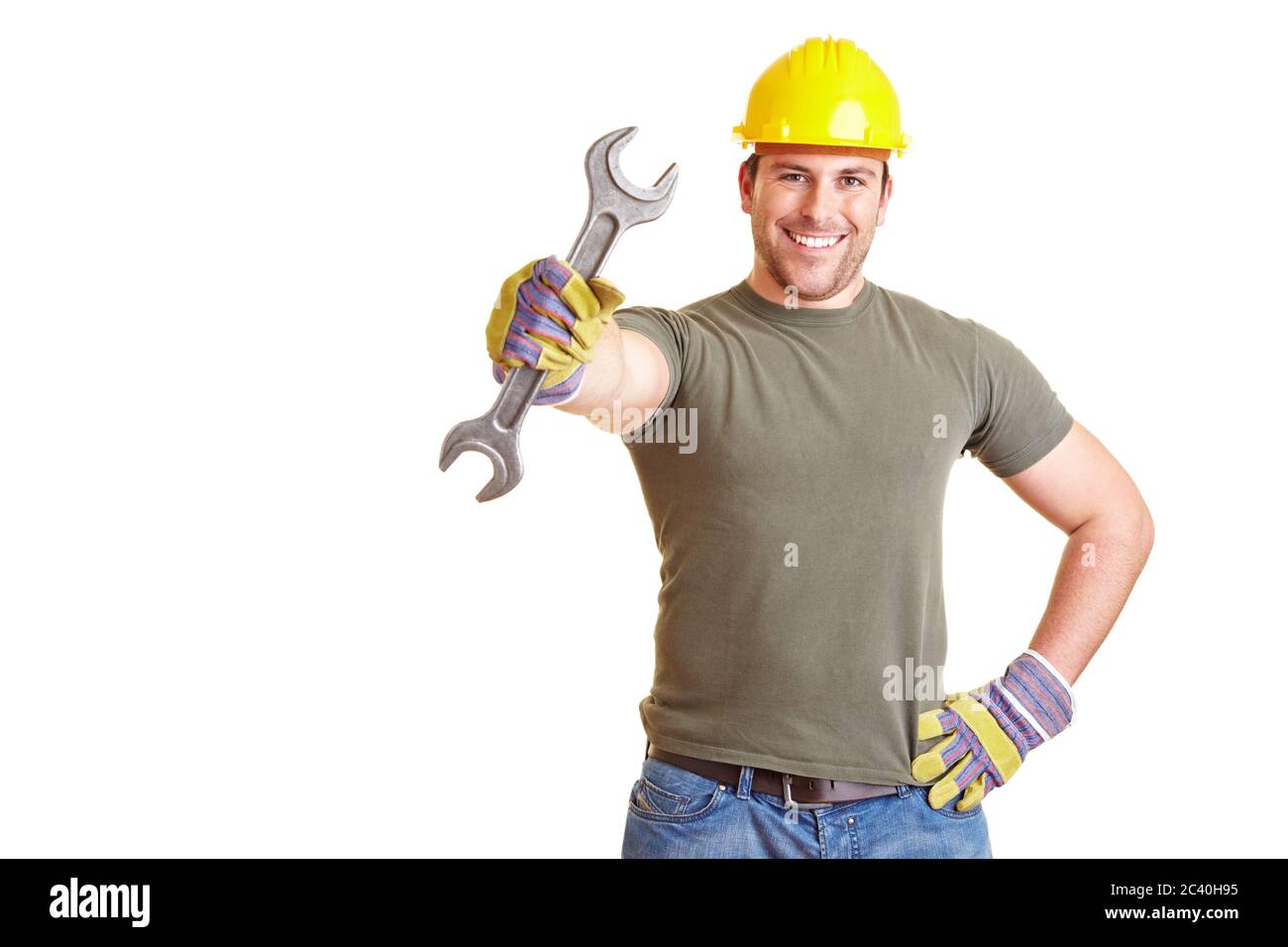 Lächelnder Bauarbeiter zeigt einen großen Doppelschlüssel mit offenem Ende Stockfoto
