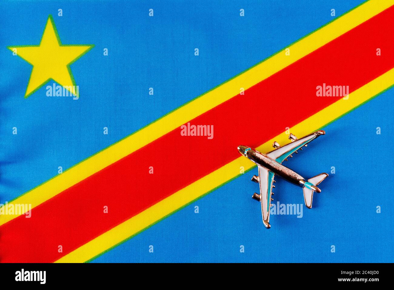 Flugzeug über Kongo-Kinshasa Flagge Reisekonzept. Spielzeug Flugzeug auf einer Flagge im Hintergrund. Stockfoto