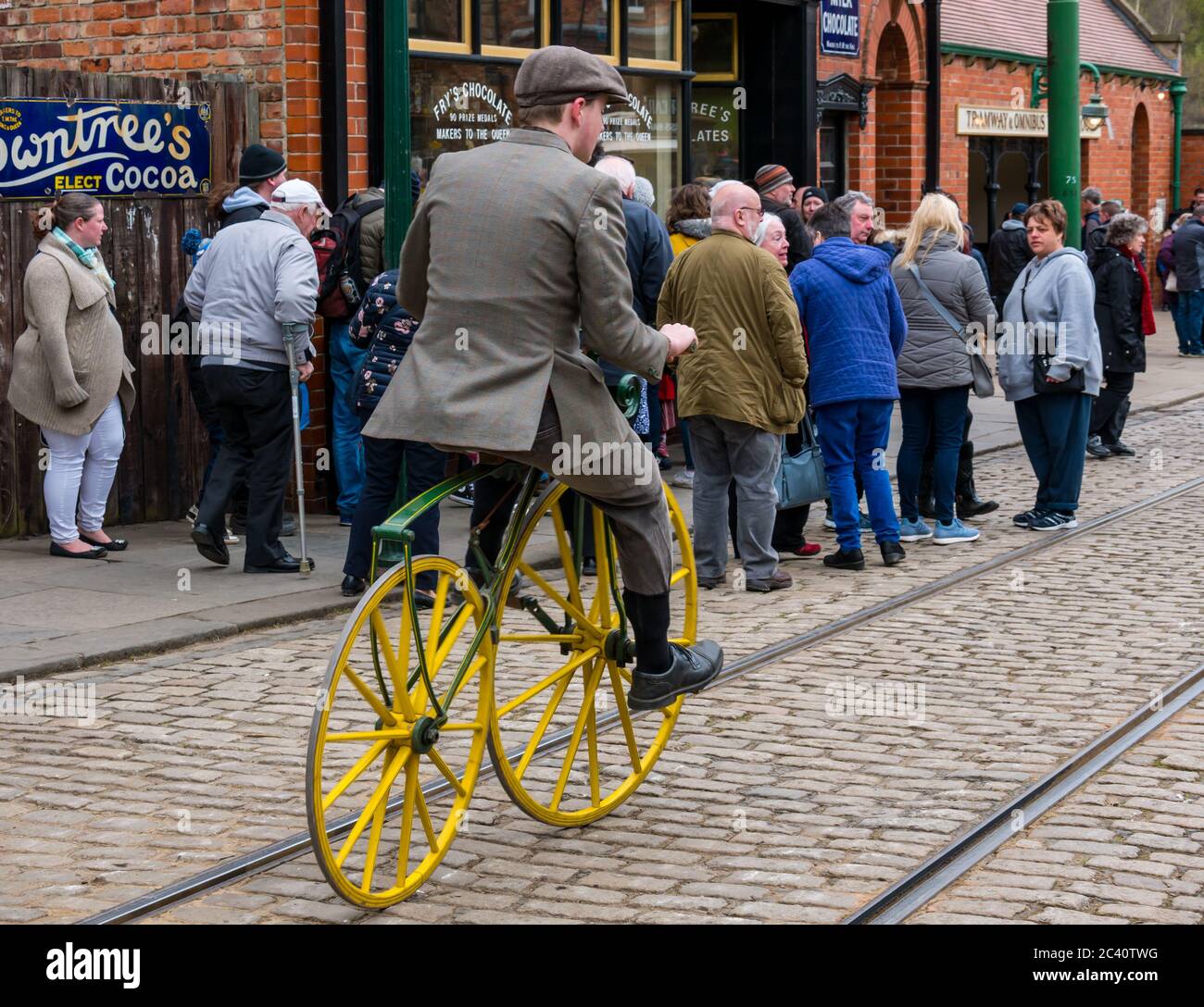 Mann, der mit einem Boneshaker-Vintage-Fahrrad in einem historischen Kostüm reitet, Beamish Museum, Durham County, England, Großbritannien Stockfoto