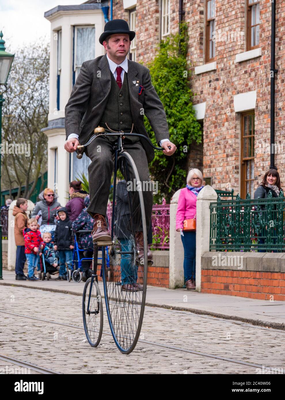 Mann, der Penny Farthing Vintage Fahrrad in Zeitkostüm reitet, Beamish Museum, Durham County, England, Großbritannien, Stockfoto