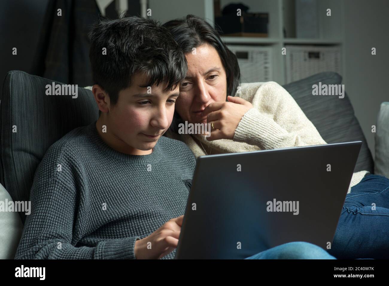 Gemeinsam zu Hause lernen, -Mutter hilft Sohn bei der Schularbeit Stockfoto