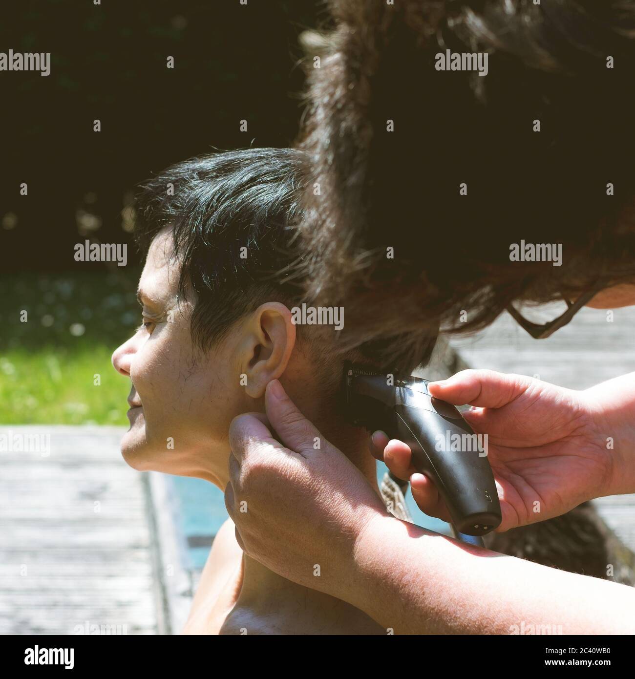 Covid 19 ockdown Haarschnitte im Garten. Familienmitglieder mussten sich gegenseitig die Haare schneiden, da die Friseure nicht öffnen durften Stockfoto