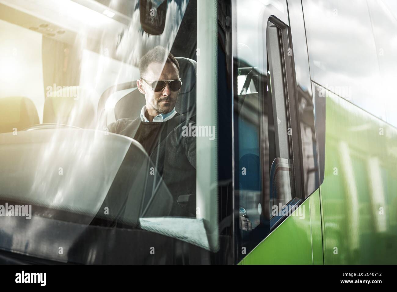 Kaukasischen Busfahrer hinter dem Lenkrad des modernen Fahrzeugs. Thema Busfahren. Konzept Für Öffentliche Verkehrsmittel. Stockfoto