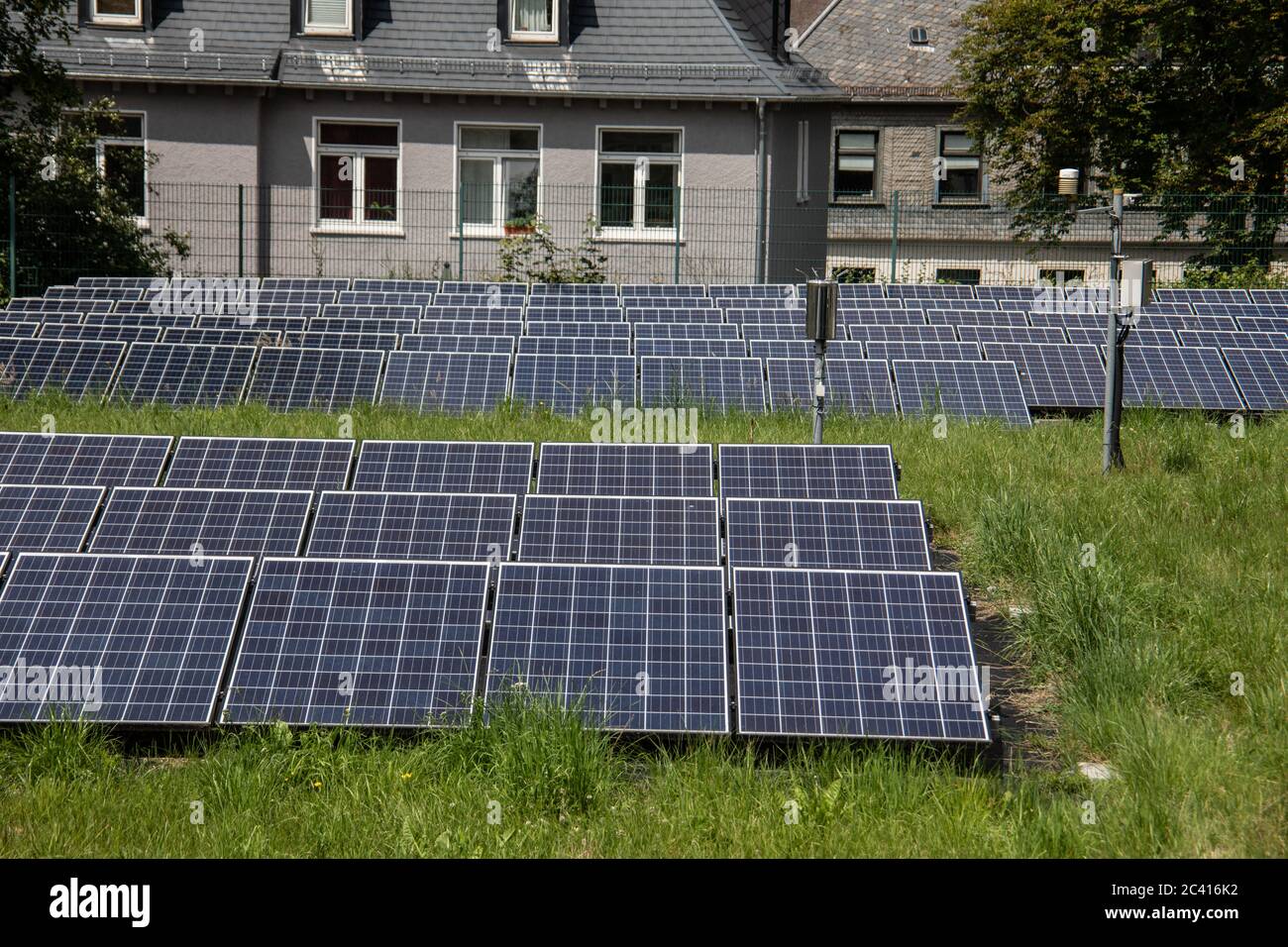 Wiese mit Feld von Solarzellen zur Stromerzeugung mit alternativen Energien Stockfoto
