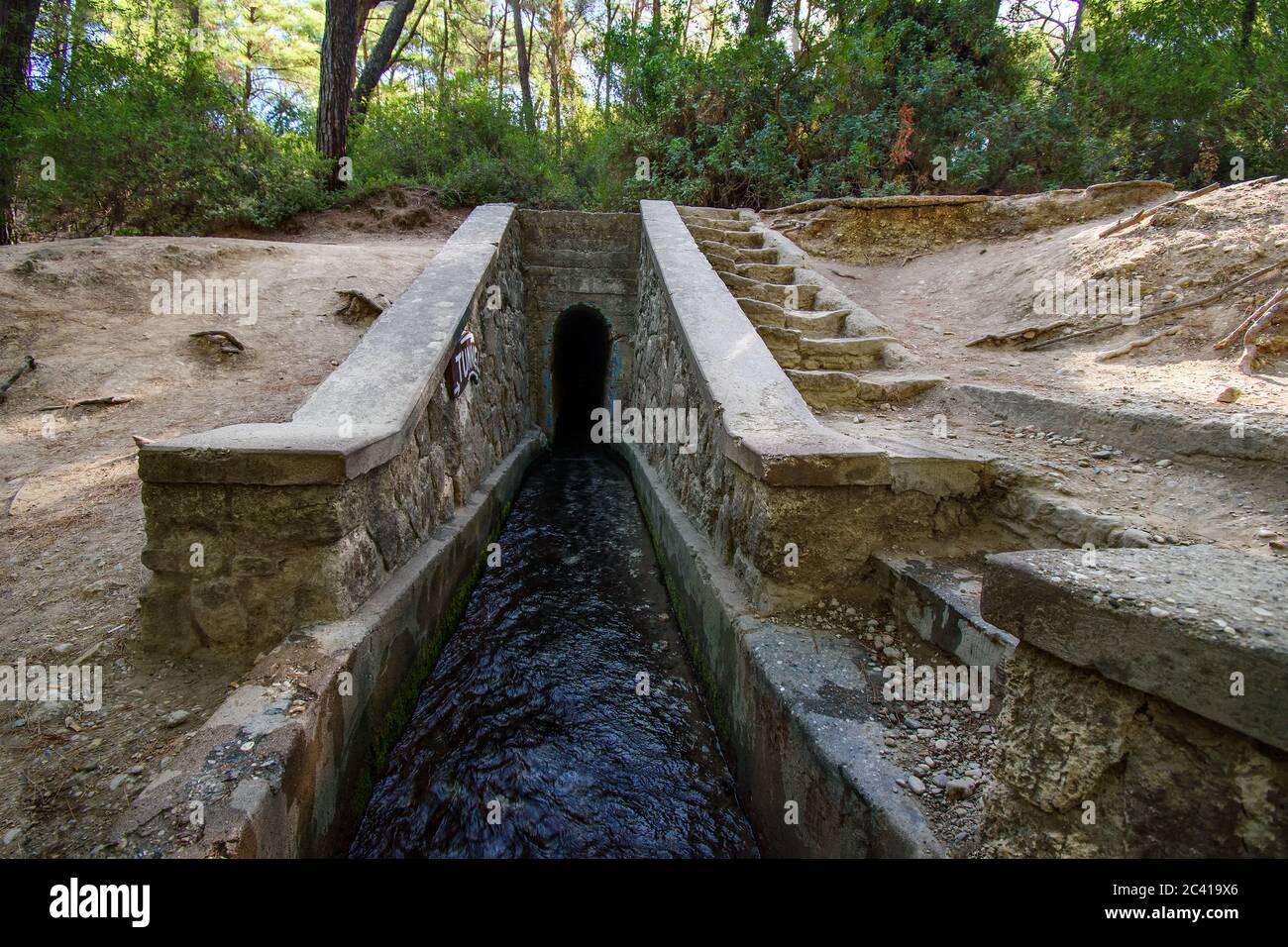 Eingang zum Tunnel auf dem Loutanis Fluss in Seven Spring (Epta Piges) im Wald bei Kolymbia (Rhodos, Griechenland) Stockfoto