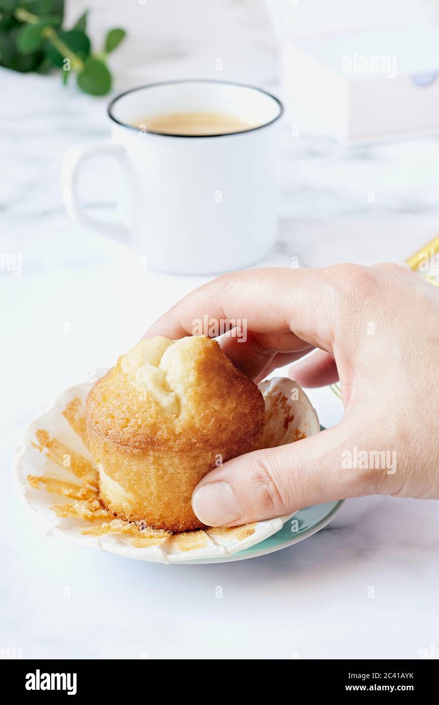Frau Hand greift einen hausgemachten Muffin. Stockfoto
