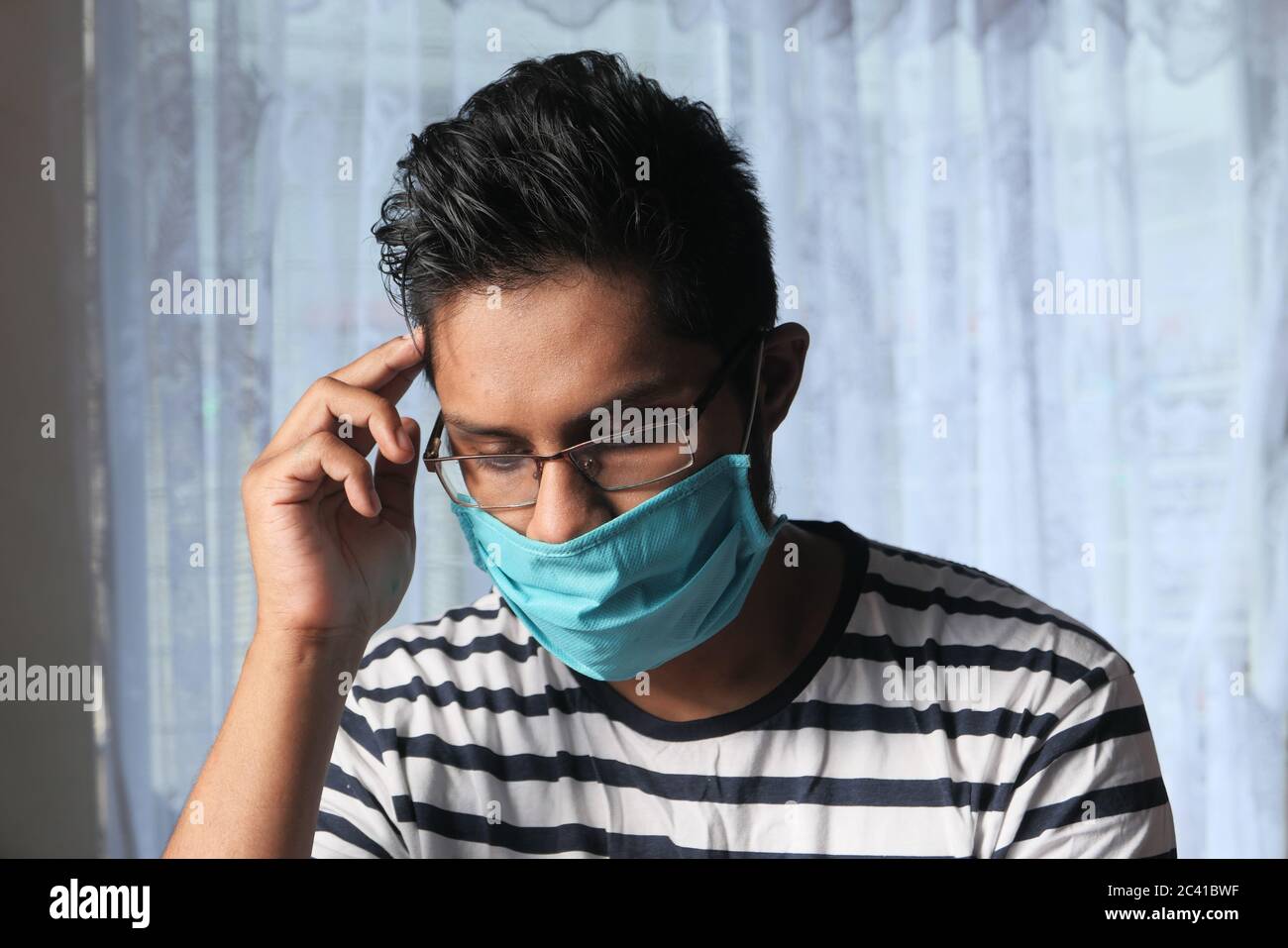 Junger Mann trägt hygienische Maske, um Infektionen zu verhindern Stockfoto