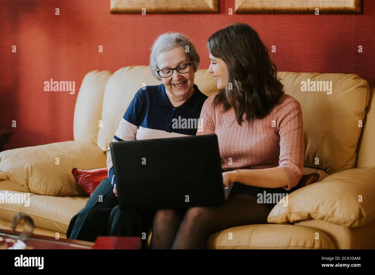 Enkelin zeigt ihrer Großmutter etwas auf dem Laptop Stockfoto Enkelin zeigt ihrer Großmutter etwas auf dem Laptop Stockfoto