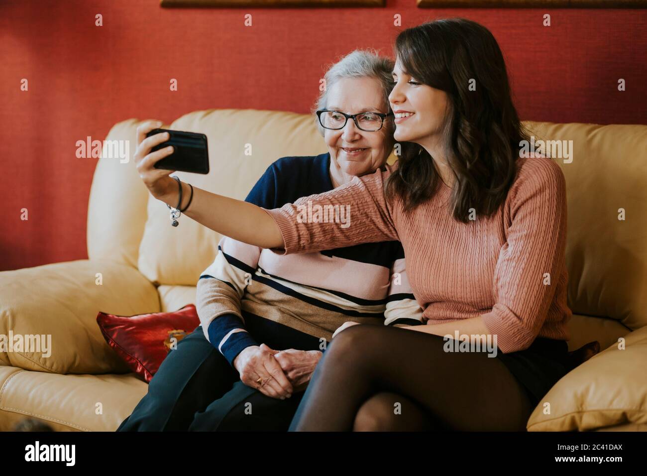 Enkelin und Großmutter machen ein Selfie auf dem Sofa Stockfoto