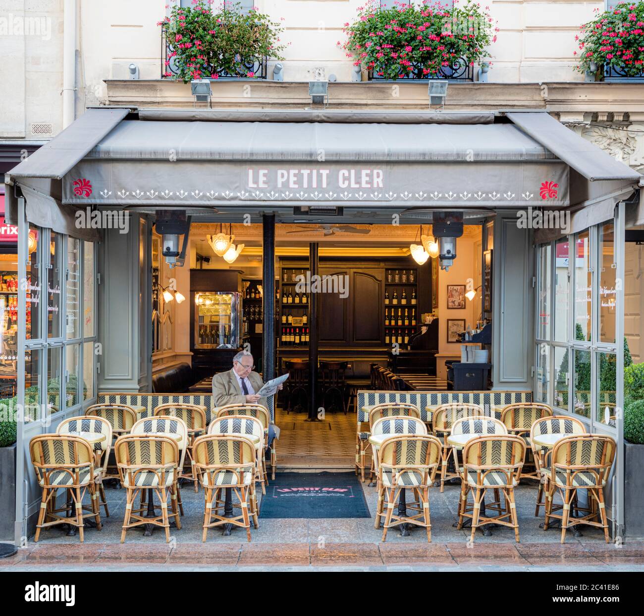 Mann liest Zeitung im Le Petit Cler - Café in der Rue Cler im 7. Arrondissement, Paris, Frankreich Stockfoto
