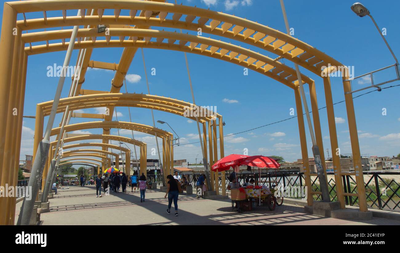San Miguel de Piura, Piura / Peru - 5. April 2019: Menschen, die eine Fußgängerbrücke über den Fluss Piura überqueren Stockfoto