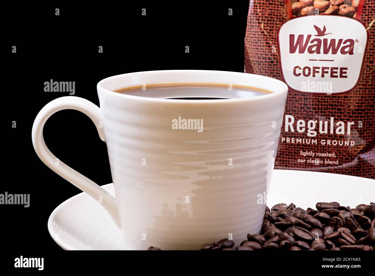 Wawa normale Kaffeetasche Nahaufnahme mit einer gebrauten Tasse Wawa Kaffee, weiße Tasse auf einem weißen Teller, Kaffeebohnen und einem festen schwarzen Hintergrund für Ausschnitte Stockfoto