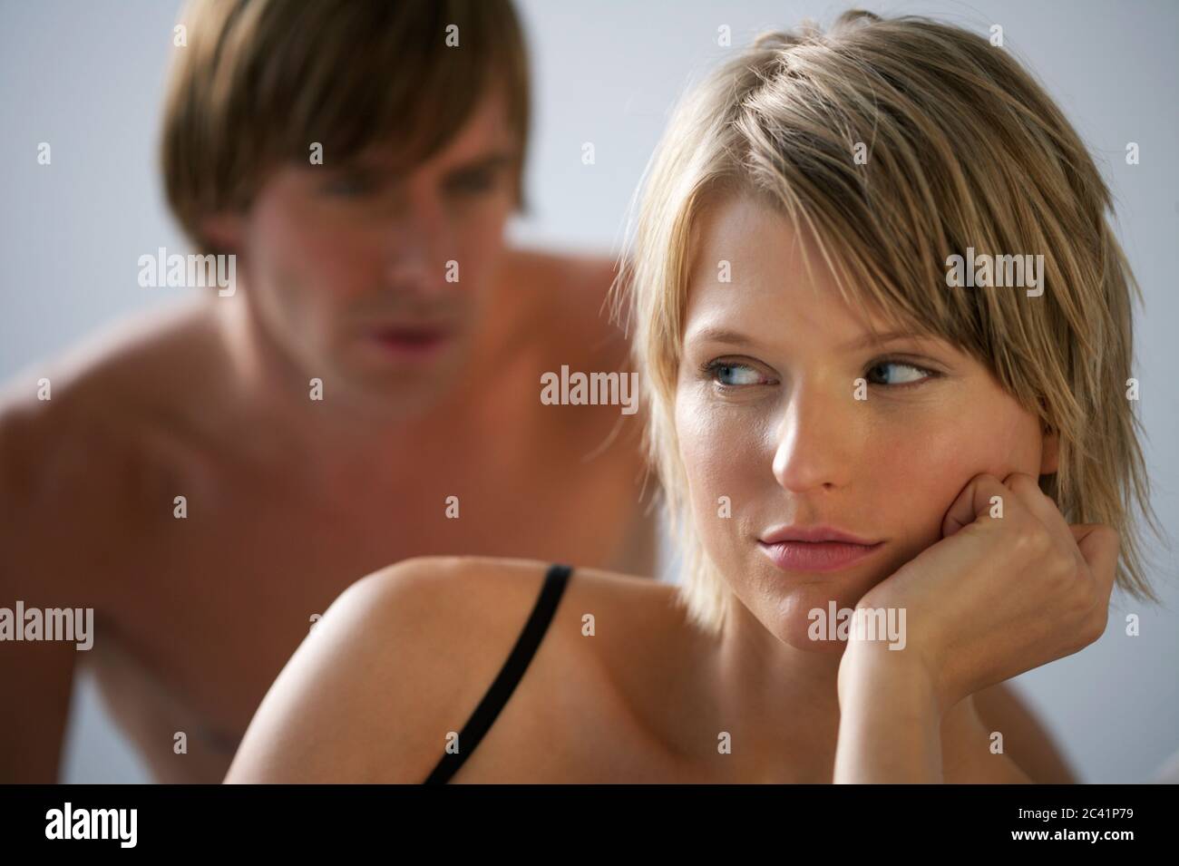 Junge Frau pouts, junger Mann im Hintergrund Stockfoto