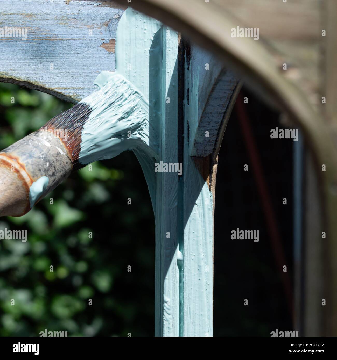 Jemand malt den Bogen und die Säule einer Laterne mit pastellgrüner Farbe Stockfoto