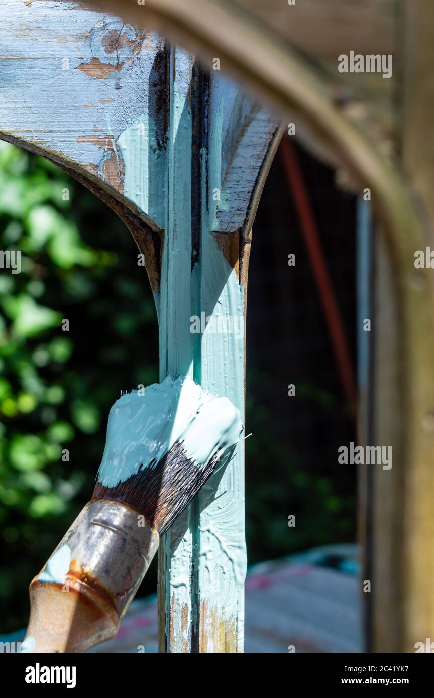Jemand malt den Bogen und die Säule einer Laterne mit pastellgrüner Farbe Stockfoto