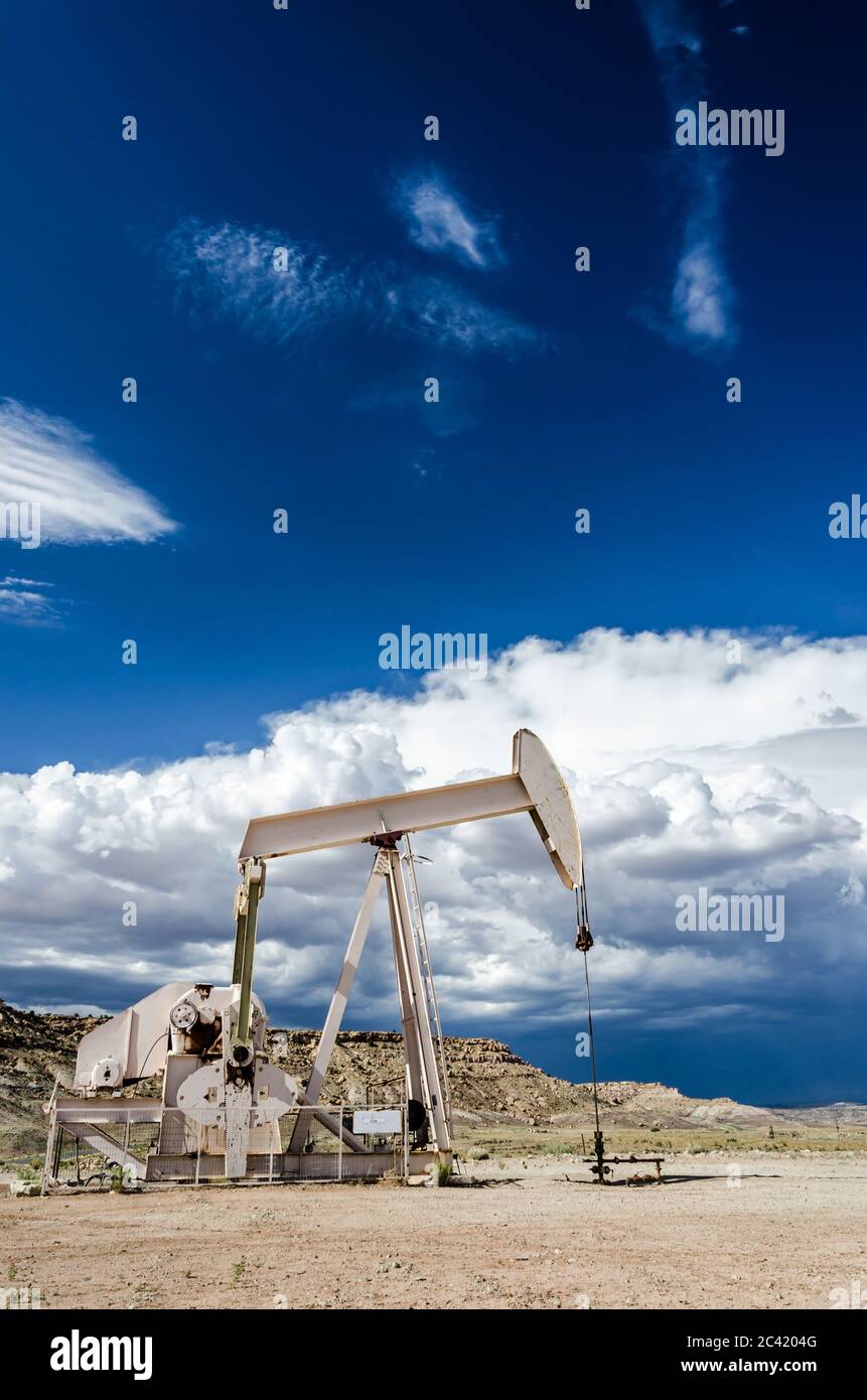 Ölpumpe in der Wüste mit dunklen Wolken im Hintergrund Stockfoto