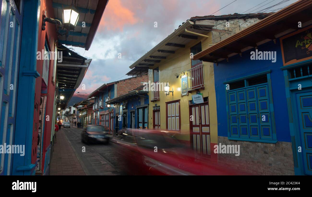 Inmaculada Concepcion de Loja, Loja / Ecuador - März 30 2019: Autos fahren an der Lourdes Straße vorbei, mit den Lichtern der Häuser, die bei Sonnenuntergang beleuchtet sind Stockfoto