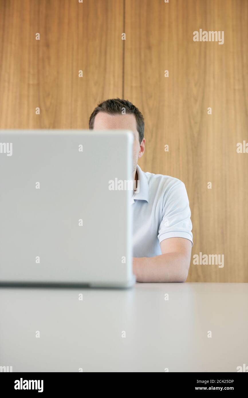Mann hinter einem Laptop - Arbeitslücke Stockfoto