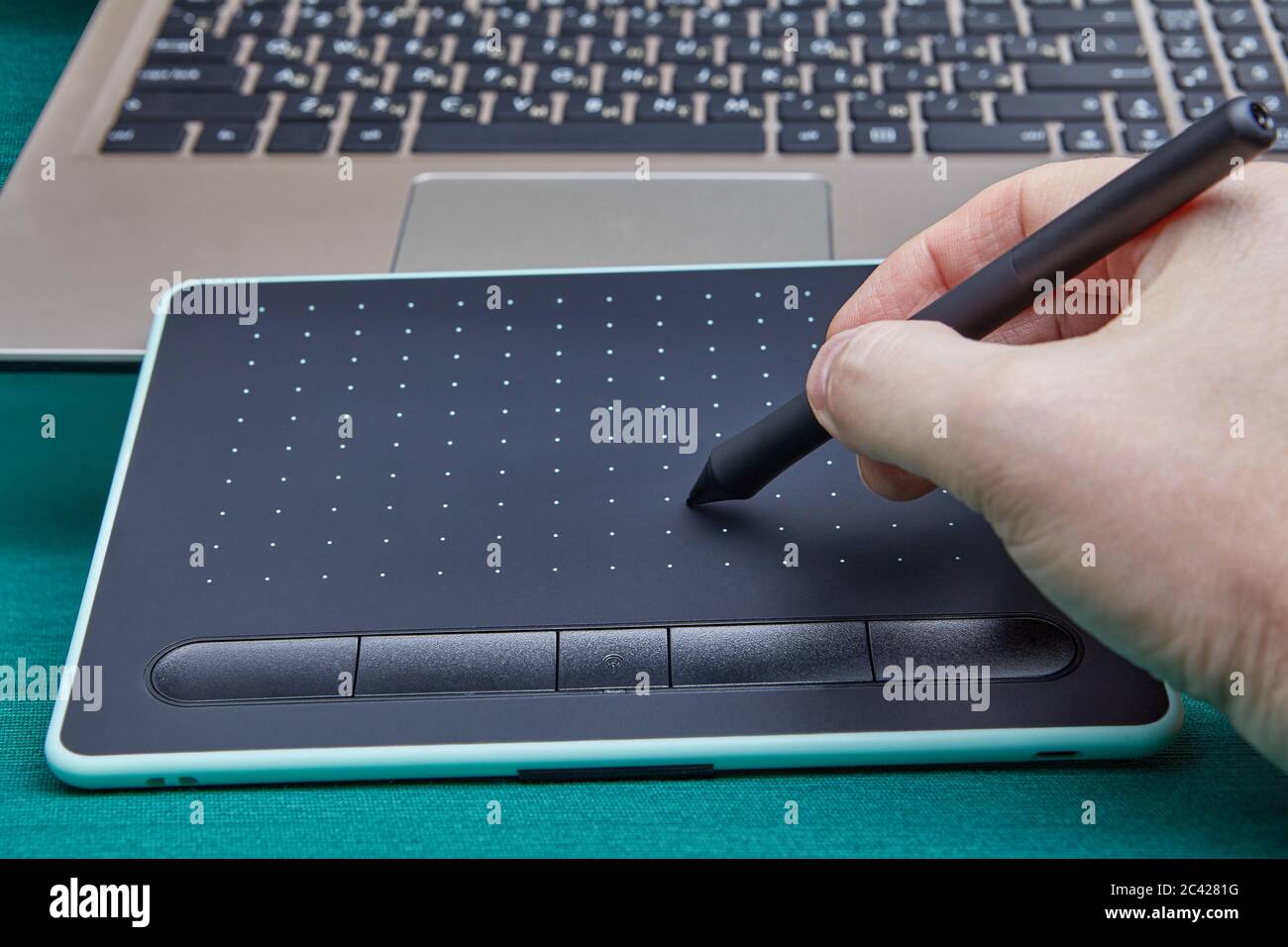 Hand eines Künstlers mit einem Stift mit einem elektronischen Zeichenbrett,  um in einem Grafikeditor-Programm auf einem PC zu arbeiten. Eingabegerät,  Tabelle Stockfotografie - Alamy