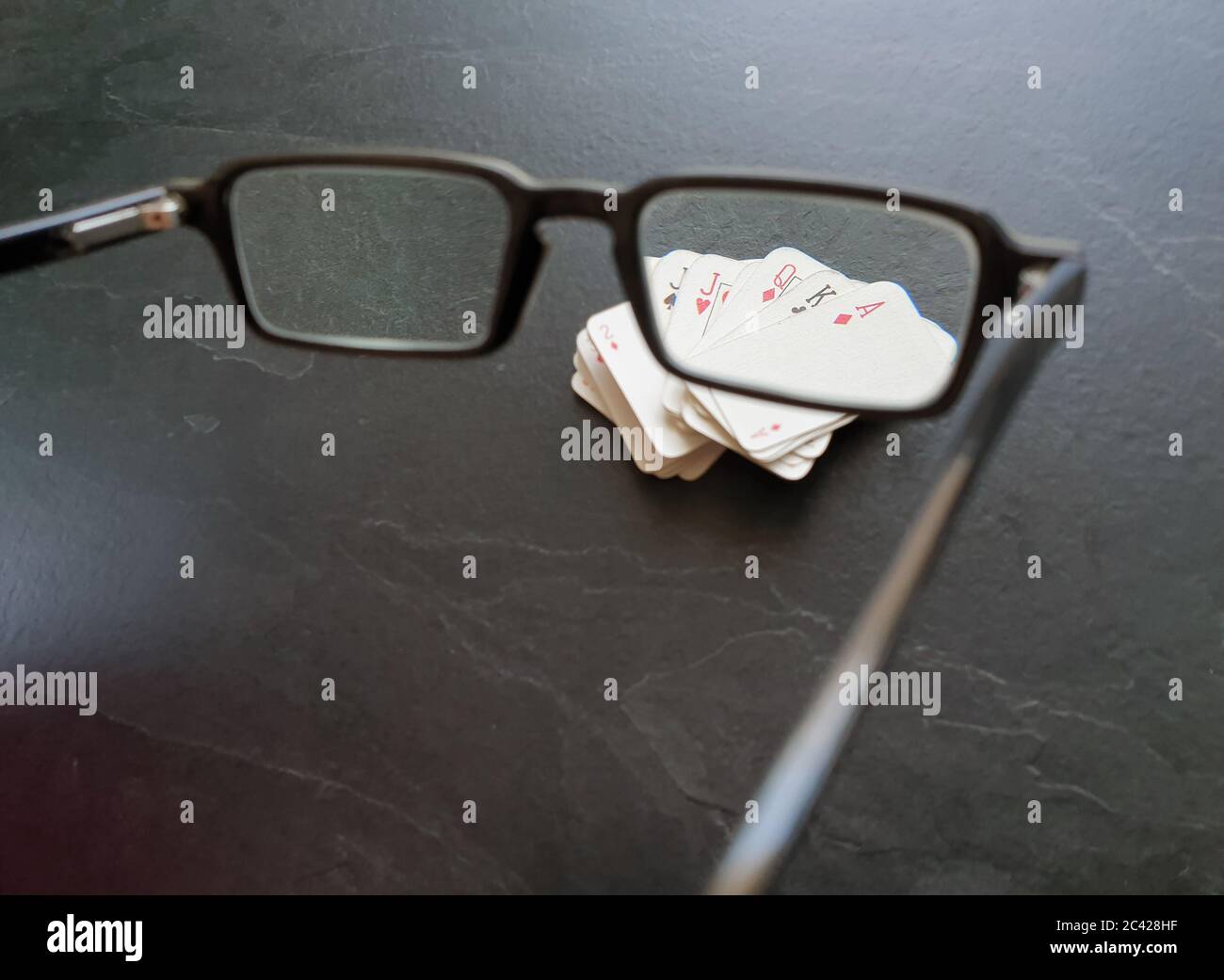 Brille und Deck von Pokerkarten auf dem Tisch als Symbol für das Glücksspiel. Isolation von Innenräumen, da soziale Distanzierung Quarantänemaßnahmen Goi einschränken Stockfoto