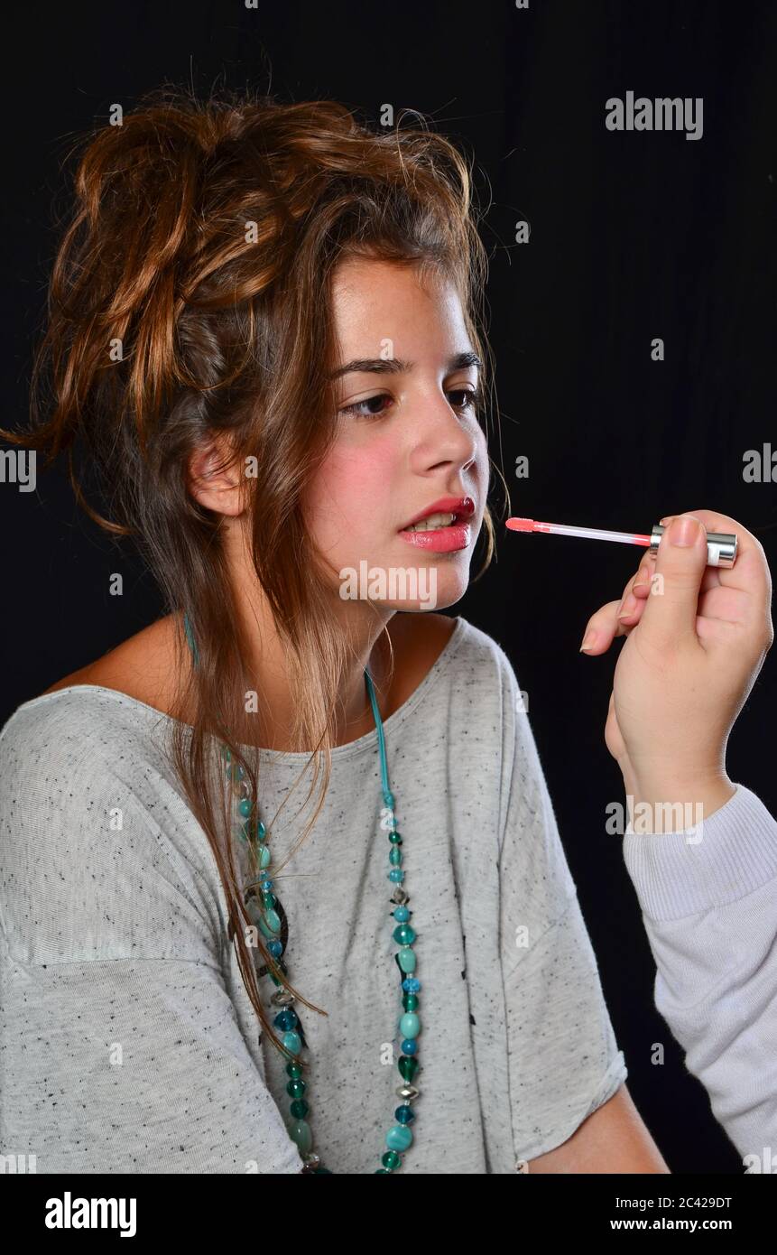 Professionelle Make-up von Teenage Brünette Mädchen während der Vorbereitung für Foto-Session, Studio vor schwarzem Hintergrund erschossen Stockfoto