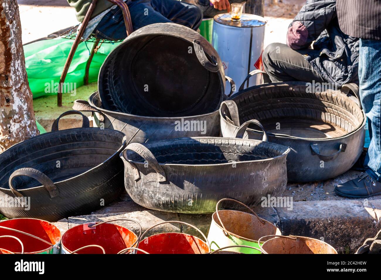 Mehrere runde Eimer aus recycelten Autoreifen sind ineinander gestapelt auf einer Straße in Sefrou, Marokko. Stockfoto