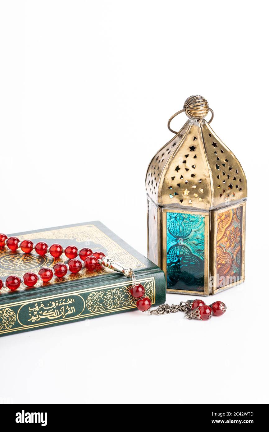 Arabische Laterne, die heiligen qoran und tasbih (Rosenkranz Perlen) isoliert gegen Weiß. Die Worte auf dem qoran sind arabischer Charakter, was den heiligen qoran bedeutet Stockfoto