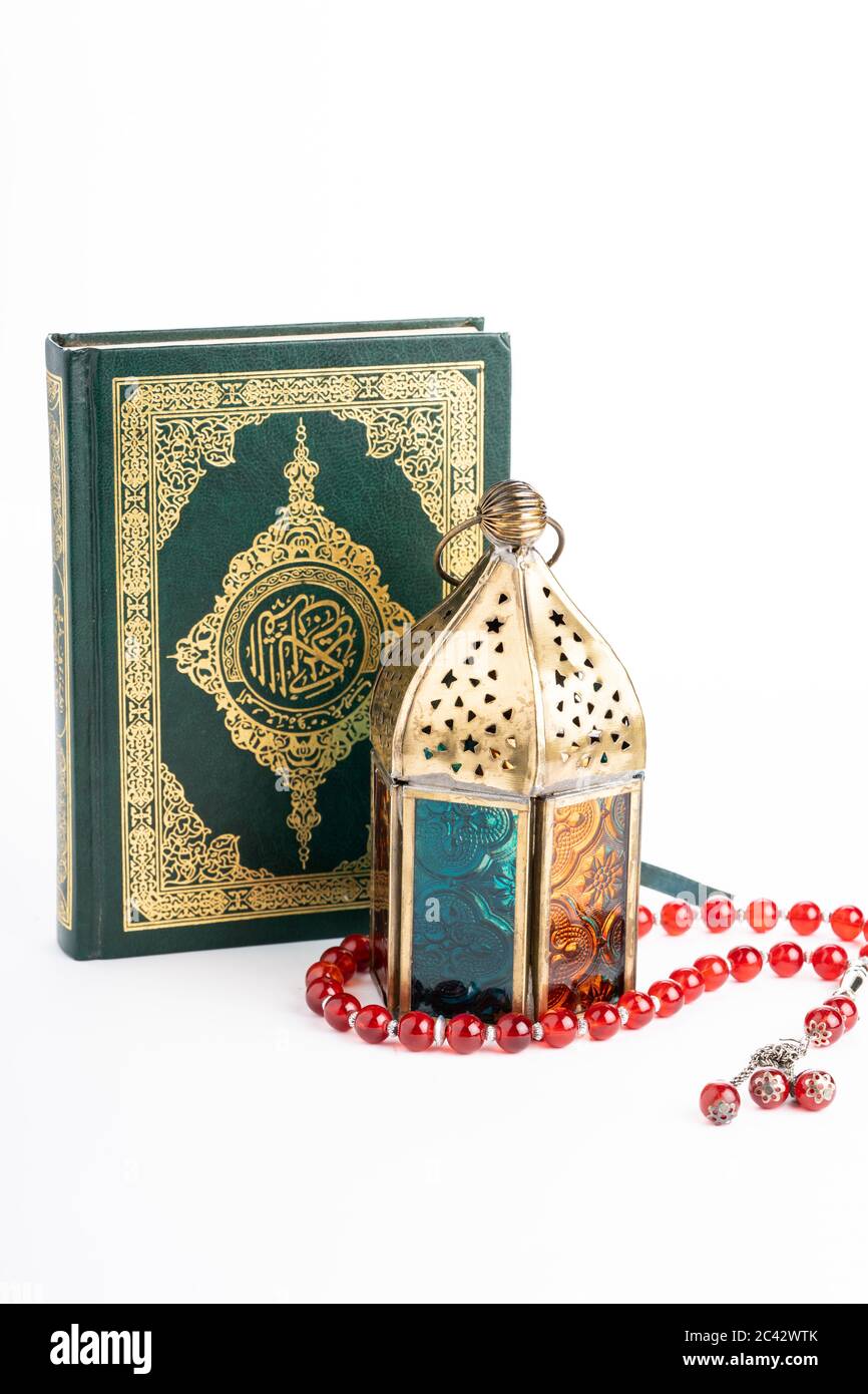 Arabische Laterne, die heiligen qoran und tasbih (Rosenkranz Perlen) isoliert gegen Weiß. Die Worte auf dem qoran sind arabischer Charakter, was den heiligen qoran bedeutet Stockfoto