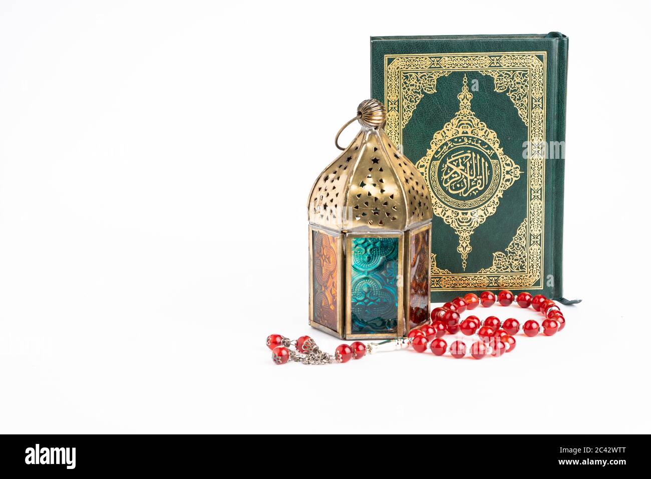 Arabische Laterne, die heiligen qoran und tasbih (Rosenkranz Perlen) isoliert gegen Weiß. Die Worte auf dem qoran sind arabischer Charakter, was den heiligen qoran bedeutet Stockfoto