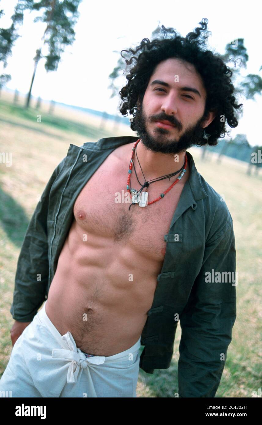 Junger Mann mit offenem Hemd im Freien - Charisma - Körperlichkeit - Zufriedenheit Stockfoto