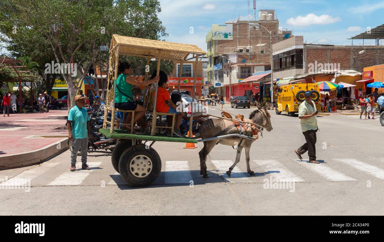 Catacaos, Piura / Peru - 6. April 2019: Touristen, die mit einem von einem Esel gezogenen Wagen in der Nähe des Paradeplatz im Stadtzentrum fahren Stockfoto