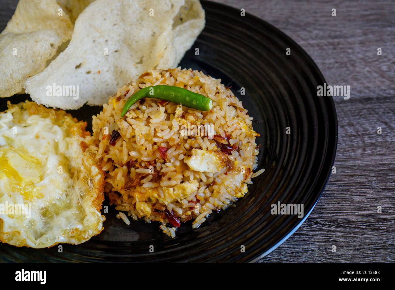 Würziger gebratener Reis mit getrockneter Chili mit Spiegelei und Fischkracker. Stockfoto