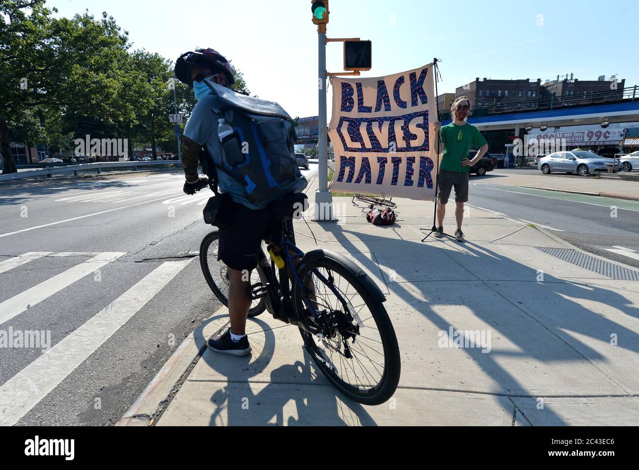 New York City, USA. Juni 2020. Sam Kuik hält ein selbstgebackenes Schild "Black Lives Matter" entlang des Queens Boulevard im Sunnyside-Teil von Queens, NY, 23. Juni 2020. Der Tod von George Floyd, der am 25. Mai von der Minneapolis-Polizei getötet wurde, hat zu Protesten im ganzen Land und auf der ganzen Welt zur Unterstützung der Bewegung Black Lives Matter geführt, um gegen systemischen Rassismus und Polizeibrutalität zu stehen.(Anthony Behar/Sipa USA) Credit: SIPA USA/Alamy Live News Stockfoto