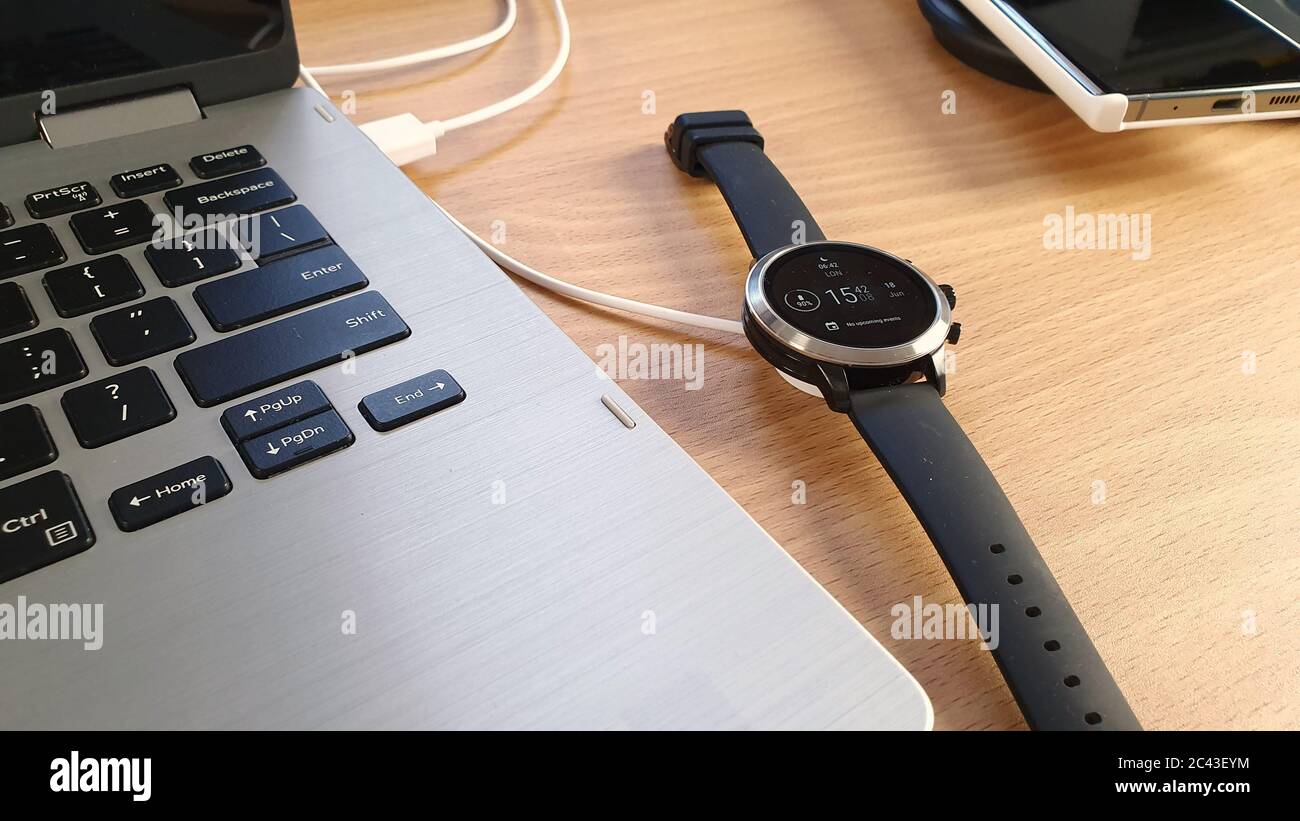 Mobiltelefon und Smart Watch auf einem dualen kabellosen Ladegerät mit Tablet und Stylus-Konzept für drahtlose Technologie und tragbare Informationsgeräte Stockfoto
