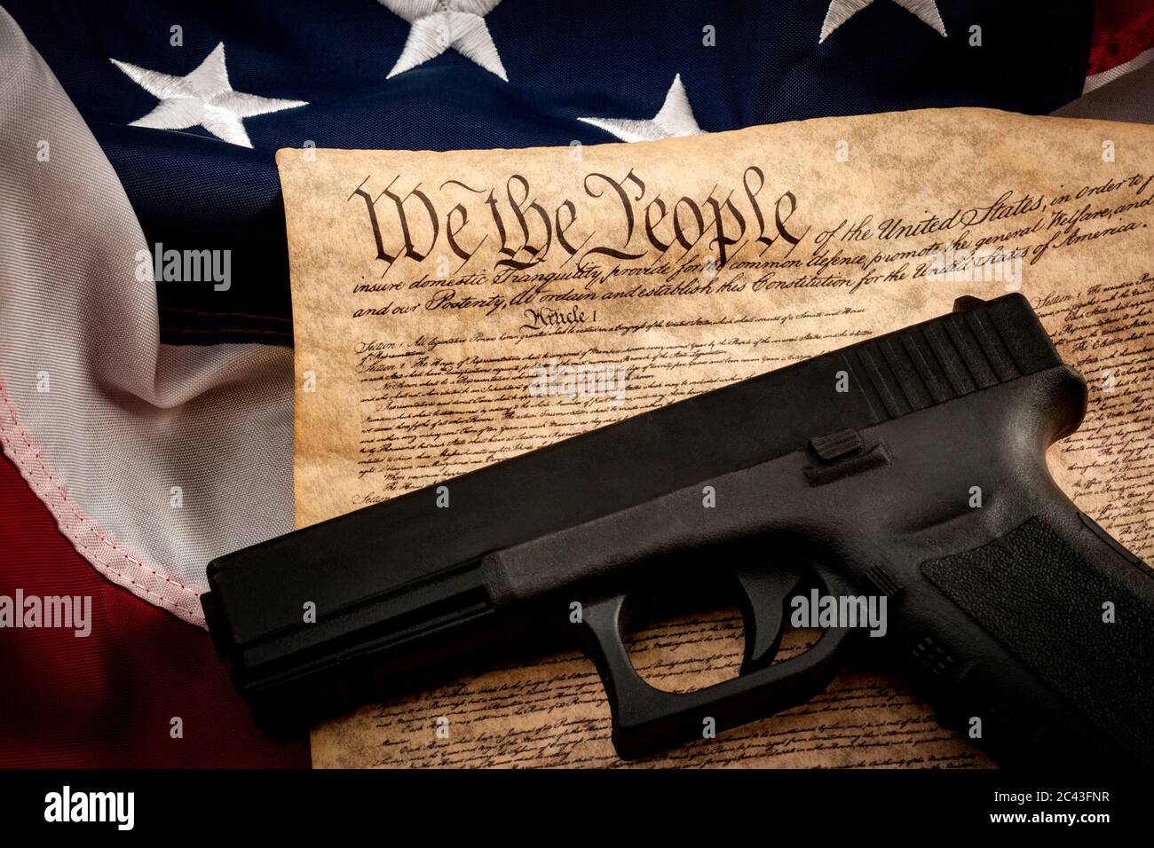 Die zweite Änderung und Waffenkontrolle in amerika Konzept mit einem Handfeuerwaffen und die amerikanische Verfassung auf der USA-Flagge mit Nahaufnahme auf der "wir den Peop Stockfoto