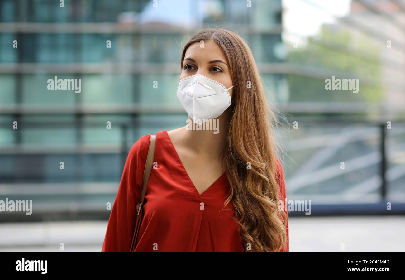 Gefühl der Verwirrung. Junge Frau in leerer Stadtstraße trägt Schutzmaske. Mädchen mit Gesichtsmaske Gefühl allein während einer Pandemie. Stockfoto