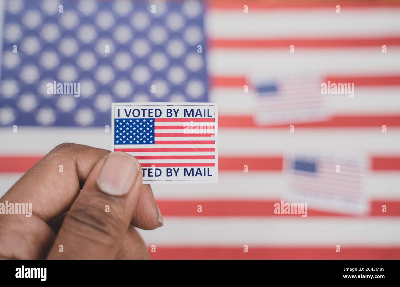 Halten Ich stimmte meine Mail-Aufkleber in Händen mit US-Flagge als Hintergrund - Konzept der per Post während der Wahl abgestimmt Stockfoto