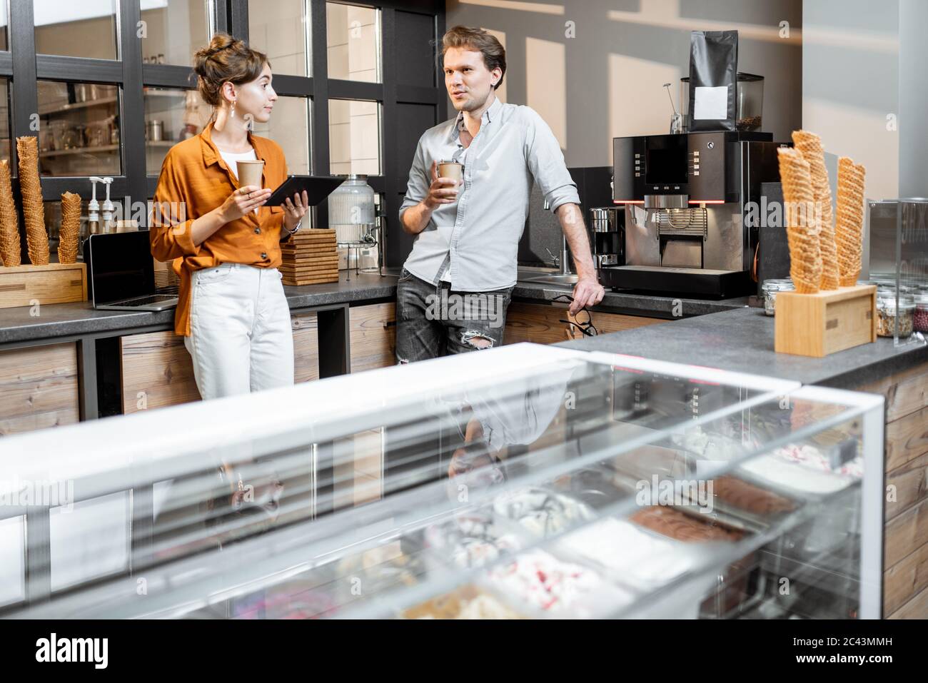 Zwei junge Manager oder Ladenbesitzer, die im Laden oder Café diskutieren. Management-Konzept für kleine Unternehmen Stockfoto