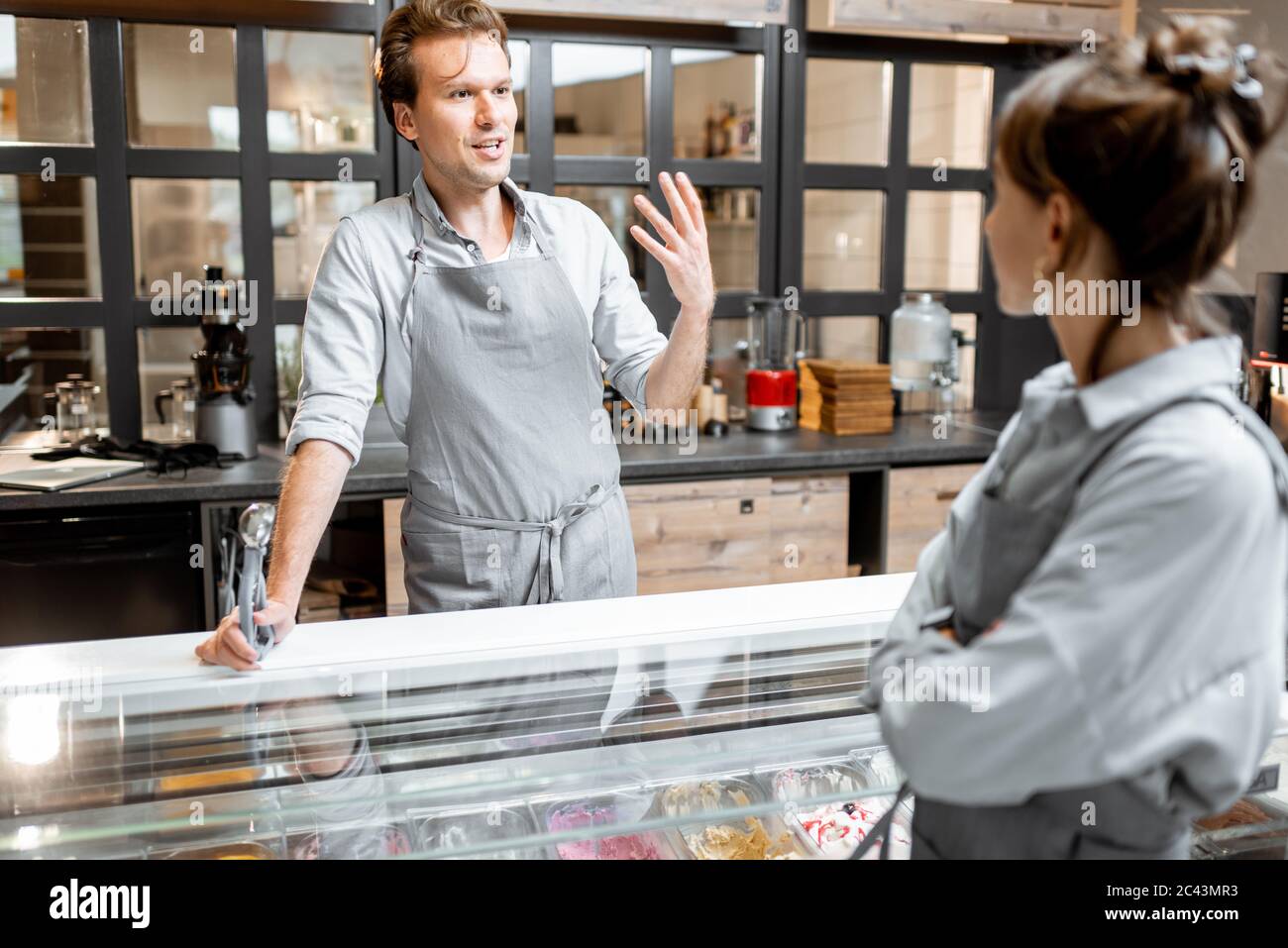 Porträt eines fröhlichen Verkäufers im Vorfeld im Gespräch mit einem Kunden in der kleinen Laden oder Café. Konzept eines kleinen Unternehmens und Arbeit im Bereich der Dienstleistungen Stockfoto